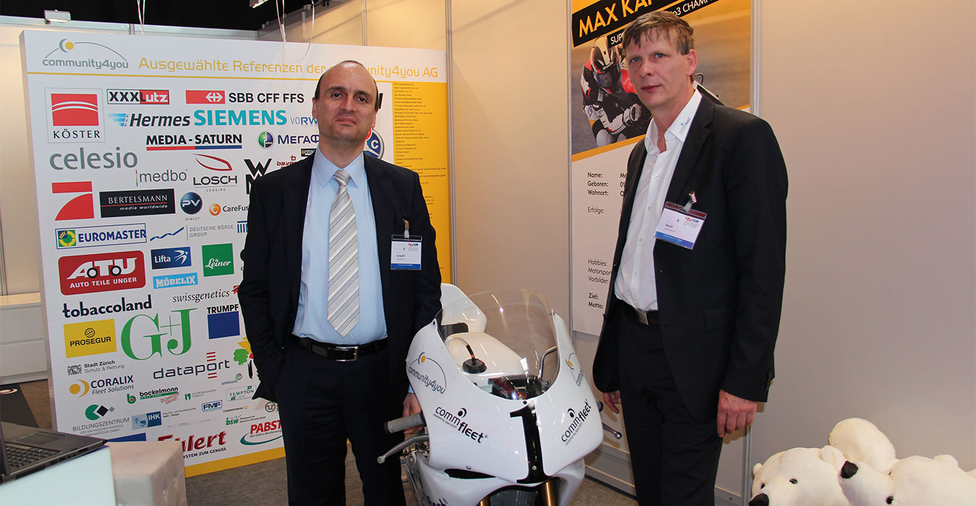 community4you AG präsentiert comm.fleet auf dem Fuhrpark-FORUM 2014 | Lavinio Cerquetti, Vorstand und Uwe Bauch, Vorstandsvorsitzender der community4you AG mit der Rennmaschine von Max Kappler